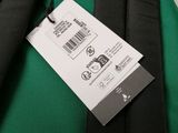 the back of a green and black backpack with a tag on it
