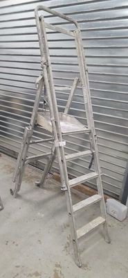 two ladders sitting next to each other in front of a garage door