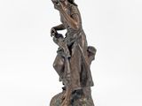 bronze statue of a woman sitting on a stool with a dog