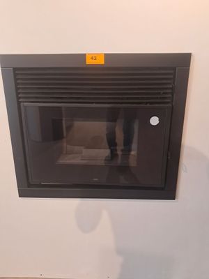une cheminée dans un coin d'une pièce, avec une personne debout à côté