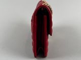 the small red purse is open on a white surface