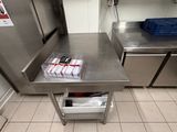 a stainless steel table with magazines on it in a commercial kitchen