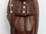 brown wooden bear figurine sitting on top of a white surface