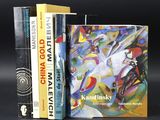 three books are stacked on top of each other on a black surface