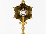 an image of a gold clock on a stand on a white background