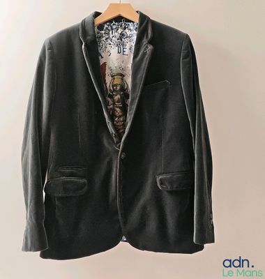 l'image d'une veste suspendue à un cintre sur un mur
