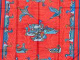 foulard en soie rouge orné d'oiseaux bleus et orange sur fond rouge