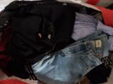 a suitcase full of clothes sitting on a bed