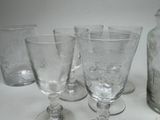 bottles and glasses are lined up on a white surface