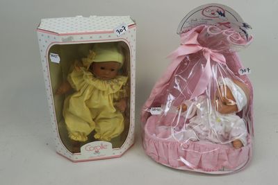 une petite poupée dans un sac rose à côté d'une petite poupée dans un sac rose