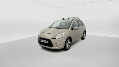 La petite voiture est garée dans une pièce blanche au sol blanc.