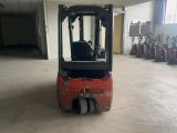 a red forklift truck parked in a large warehouse