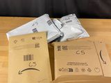 two boxes of white mail sitting on top of a wooden table
