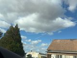 a plane that is flying in the sky over a house
