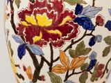 a vase with a floral design on it sitting on a table