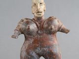 une vieille figurine représentant un homme coiffé d'un chapeau