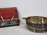 a small silver bowl and a silver spoon on a table