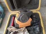 une mallette jaune contenant des outils, posée par terre