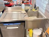 a kitchen with a sink, dishwasher, and a chair in it