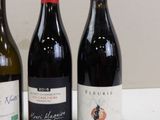 three bottles of wine are lined up on a table