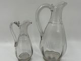 two clear glass vases with a handle and a handle