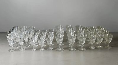 twelve crystal wine glasses lined up in a row on a table