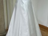 a white dress on a mannequin display in a room