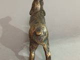 brass statue of a dog on a white surface
