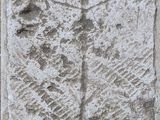 une plaque en pierre sur laquelle est gravée une croix, fixée à un mur