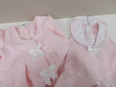 une chemise rose et une robe rose posées sur une table blanche