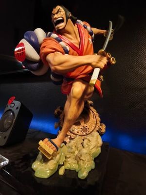a figurine of a man holding a sword and a ball