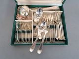 a green box with silverware in it on a table