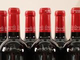 several bottles of red wine are lined up on a table