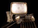 a silver tray with spoons, forks, and a tray with a mirror on it