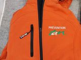 an orange jacket with the words prevention on it next to a pair of shoes