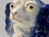 a blue and white dog figurine that is on display