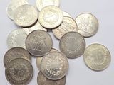 a pile of silver coins on a white surface