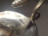 a silver plate with a snake on top of it