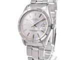 the watch is silver in color and has roman numerals on the dial
