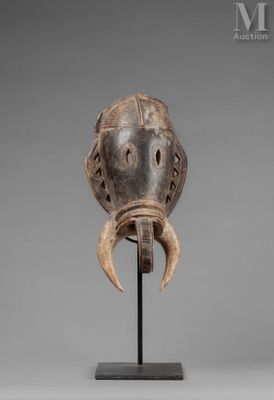 a wooden mask with horns on a stand