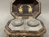 an old wooden box with two silver dishes inside of it
