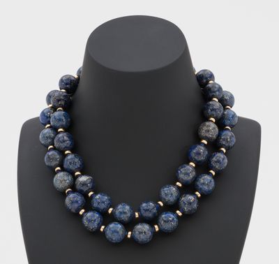 un collier composé de perles de lapis-lazuli et d'or, présenté sur un mannequin