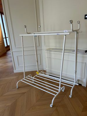 une photo d'un portant à vêtements dans un coin d'une pièce