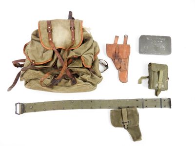 a backpack, belt, knife, and other items on a white surface