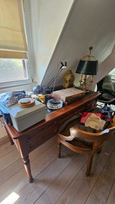 une photo d'une pièce en désordre avec un bureau et une chaise