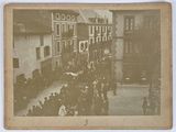 an old photo of a crowd of people walking down the street