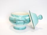 a blue and white bowl with a lid on a white surface