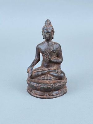 une ancienne statue en bronze représentant une personne assise en position du lotus