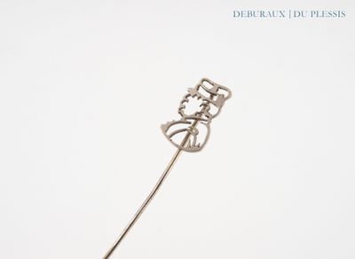 a silver stick with a flower on it on a white surface