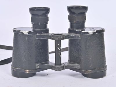an old pair of binoculars sitting on top of a white surface